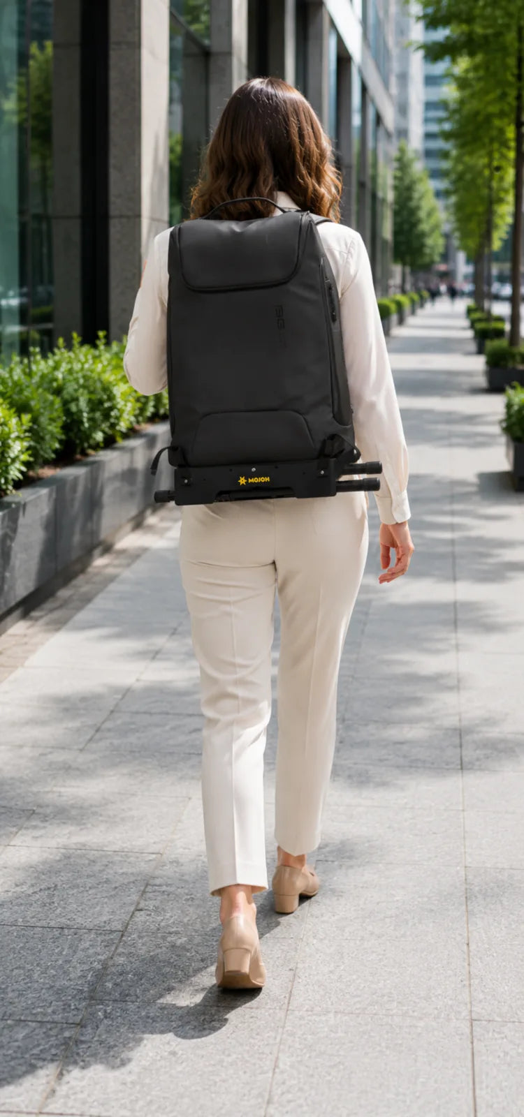 Rear carry view of the 7-inch depth of the Ryzer Go mounted to a black commuter backpack with its legs folded for travel